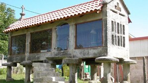 A stone building with a tiled roof, large windows, and a cross on top. - Os Areeiros (Vilaboa)