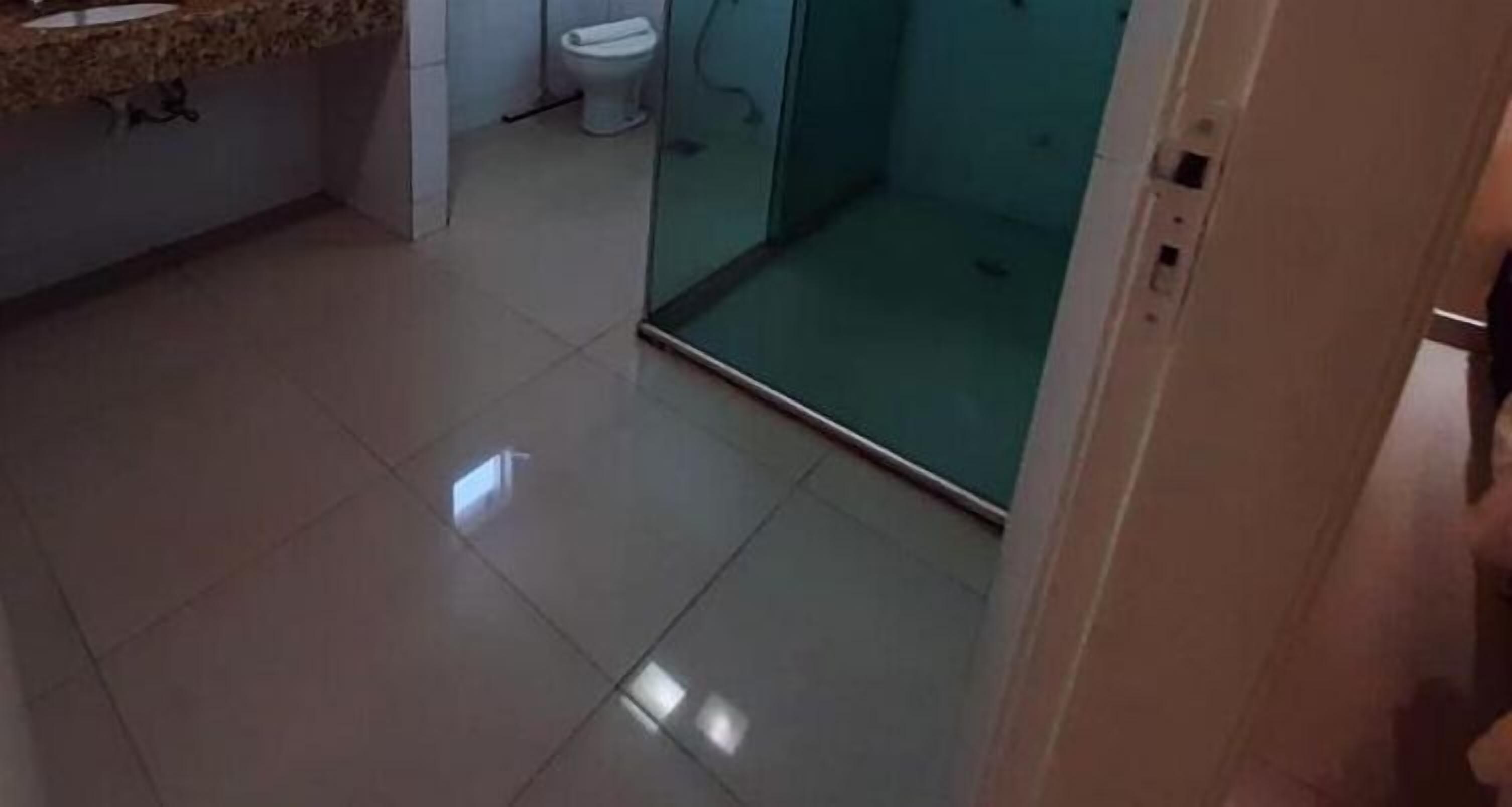 A bathroom with a toilet, a sink, and a glass shower enclosure.