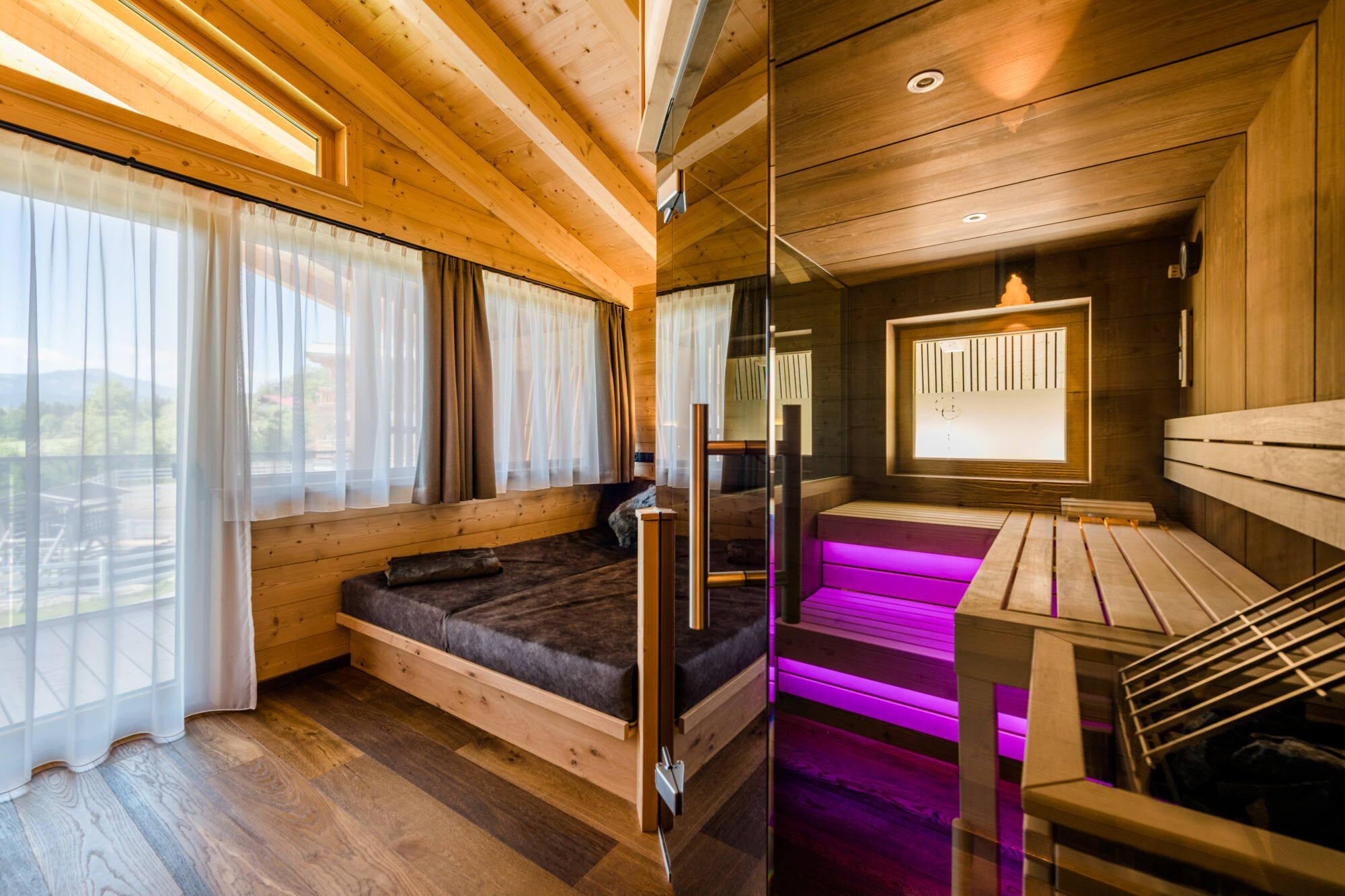 A wooden cabin interior with a bed, a bench, and a table.
