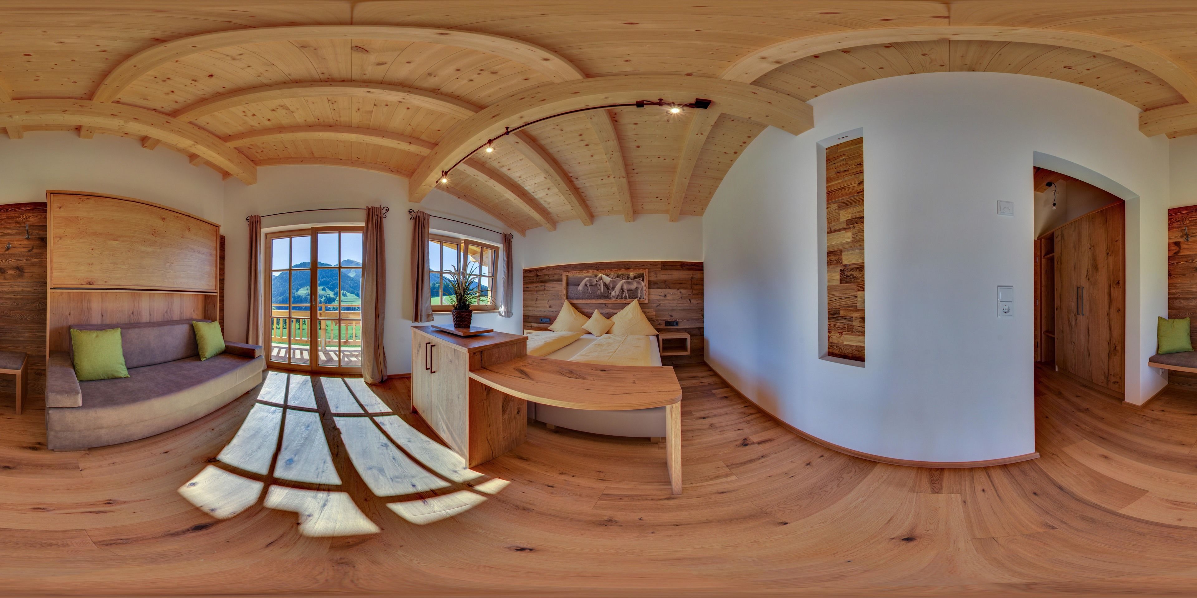 Une pièce spacieuse dotée d’un plancher en bois, d’un plafond voûté et d’une grande fenêtre offrant une vue sur l’extérieur.