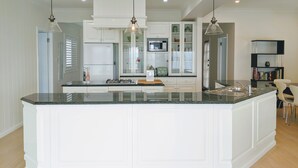 A modern kitchen with white cabinetry, a central island, and pendant lighting.