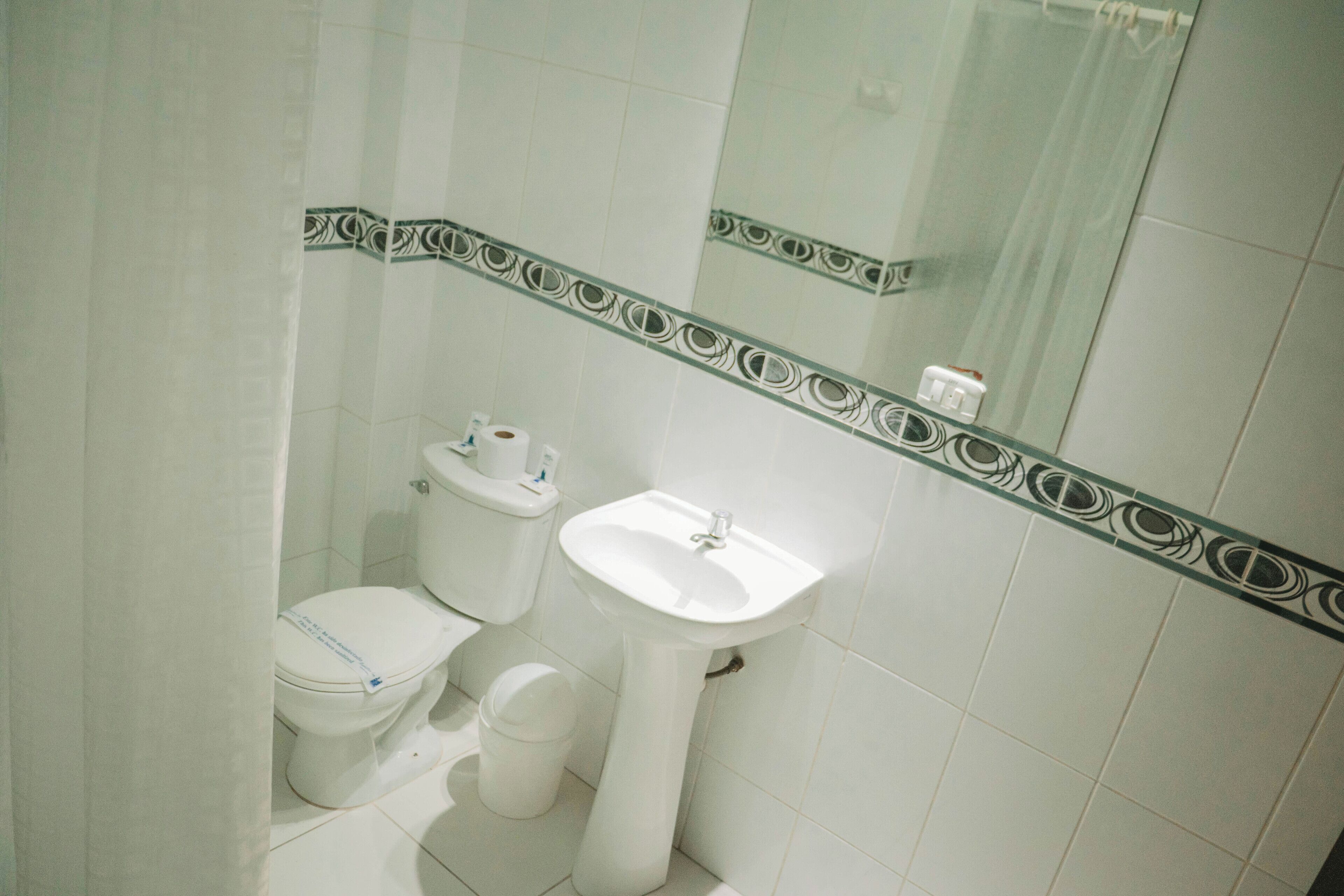 Un baño con inodoro, lavamanos y espejo.