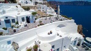 Un pueblo costero con edificios encalados, zonas de estar al aire libre y vistas al mar.