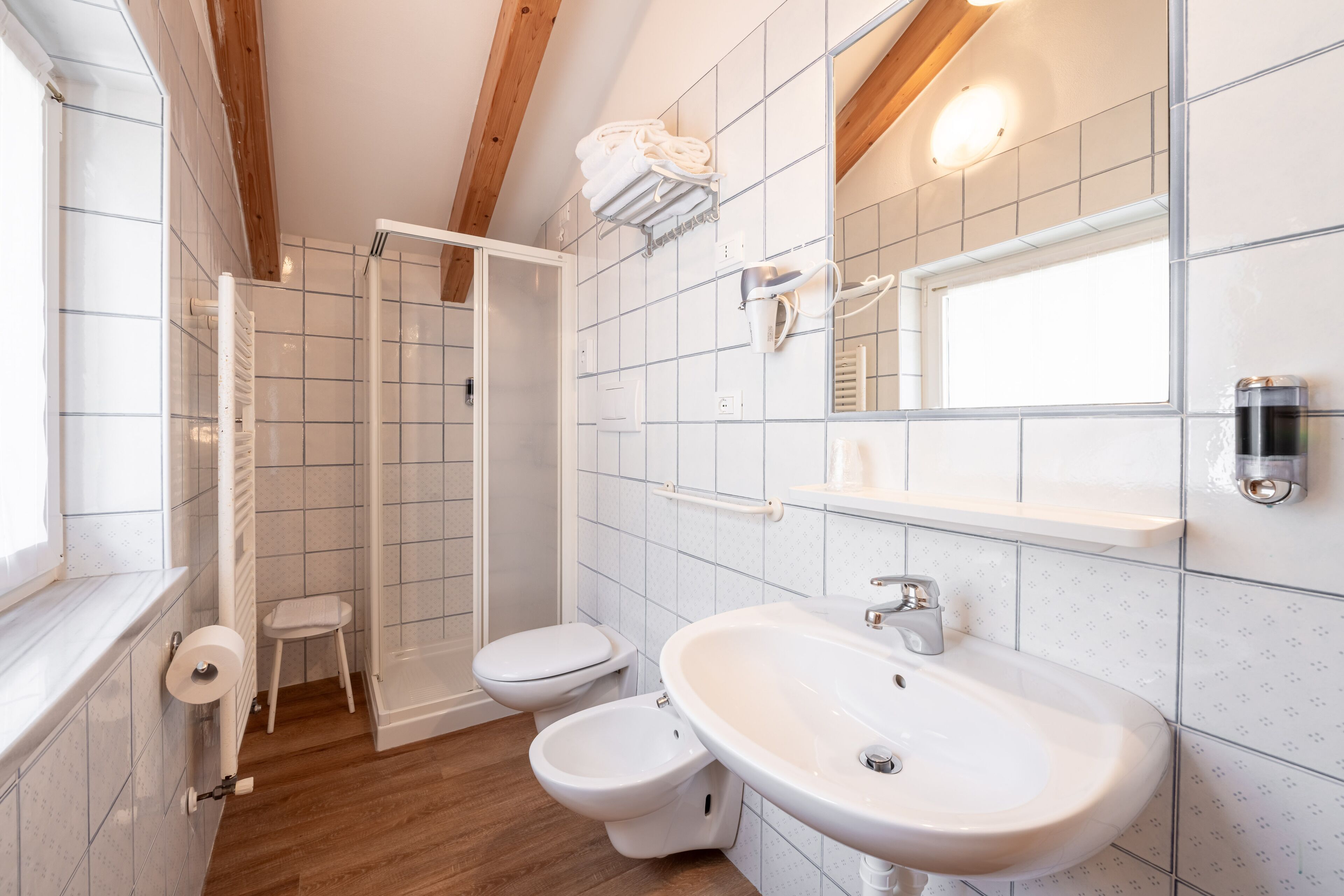 Un baño con ducha, inodoro, bidé y lavabo.