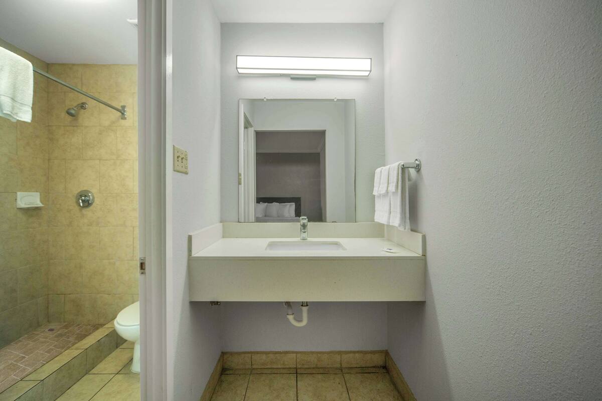 Ein Badezimmer mit Waschbecken, Spiegel und Dusche.
