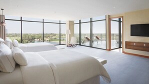 Ein Hotelzimmer mit zwei großen Betten, einem Balkon mit Blick auf einen Golfplatz und einem Flachbildfernseher.