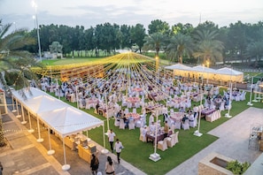 An outdoor event with multiple tents and tables set up on a grassy area. - VOGO Abu Dhabi Golf Resort & Spa (Abu Dhabi)