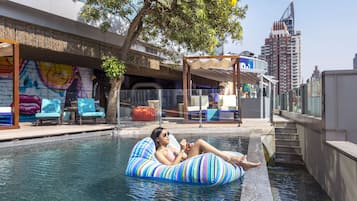 Relax by the pool surrounded by lounge chairs and a covered seating area.