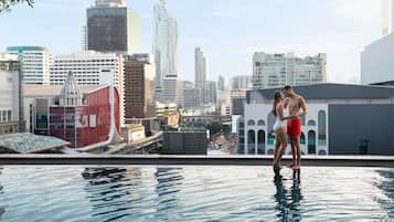 A cityscape with modern buildings and a rooftop pool area.
