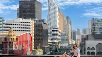 A cityscape with modern buildings, a red structure, and a pool area.