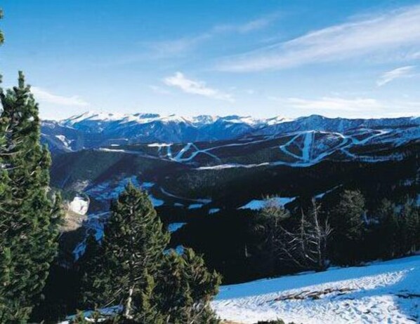 Paisaje montañoso con picos nevados y cielo despejado.