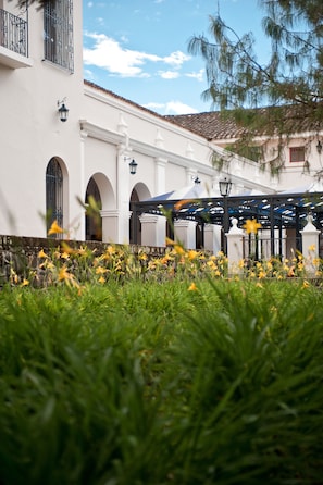 A building with white walls, arched windows, and a tiled roof. - Dann Monasterio Popayan (Popayán)