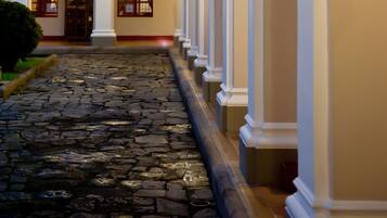 Stroll through the serene courtyard, surrounded by white-walled buildings with arched doorways and balconies.