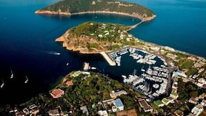 An aerial view of a coastal town with a marina, boats, and residential buildings. - La Suite Boutique Hotel (Procida)