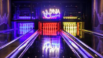 A bowling alley with neon signs and multiple lanes.
