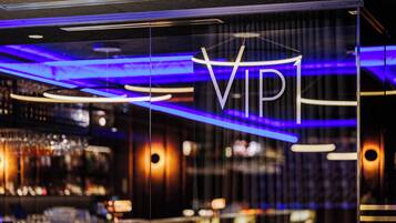A modern interior with a VIP sign, ambient lighting, and a bar area.
