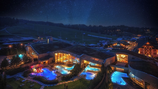A resort with multiple swimming pools, a large building with a glass facade, and a starry night sky. - Hotel Bania Thermal & Ski (Bukowina Tatrzanska)