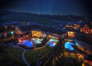 A resort with multiple swimming pools, a large building with a glass facade, and a starry night sky. - Hotel Bania Thermal & Ski (Bukowina Tatrzanska)