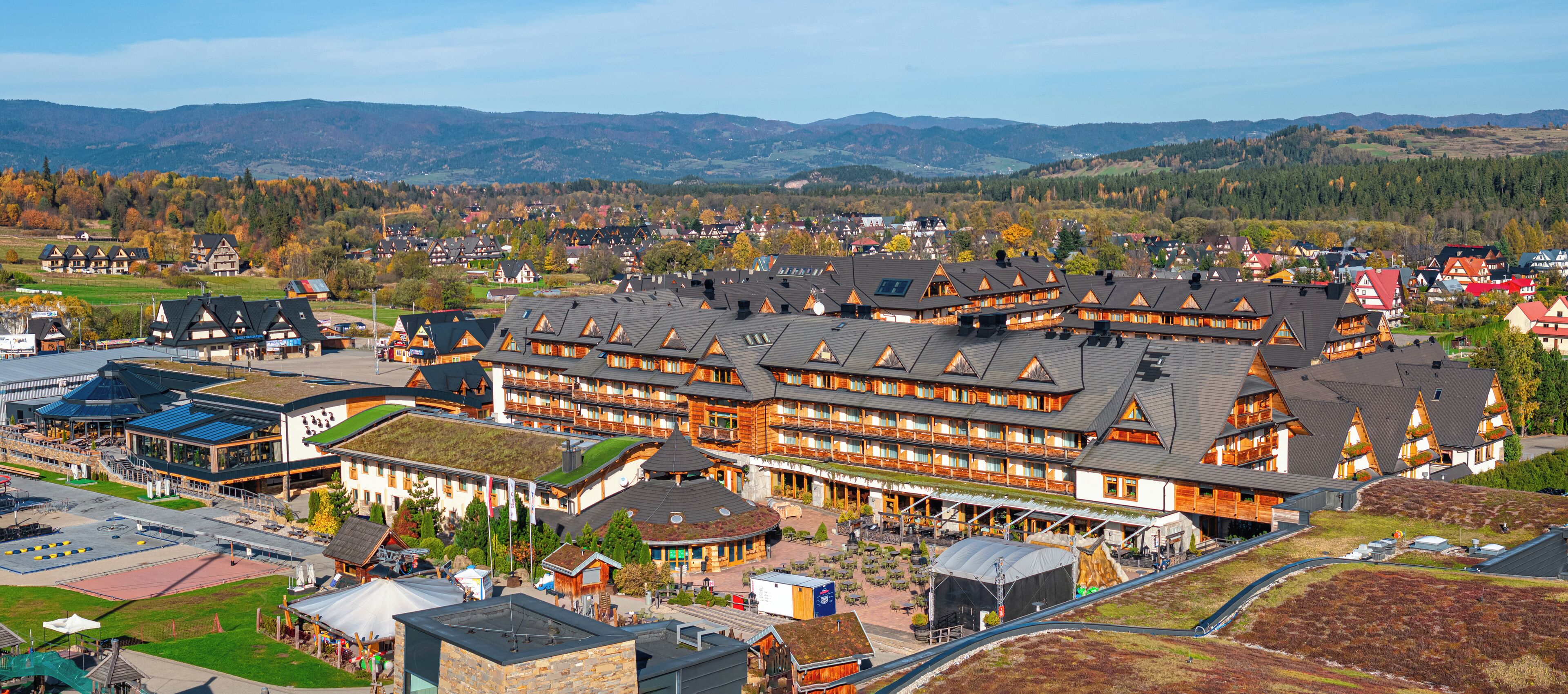 A large hotel with multiple floors, a central courtyard, and a view of the surrounding town and mountains.