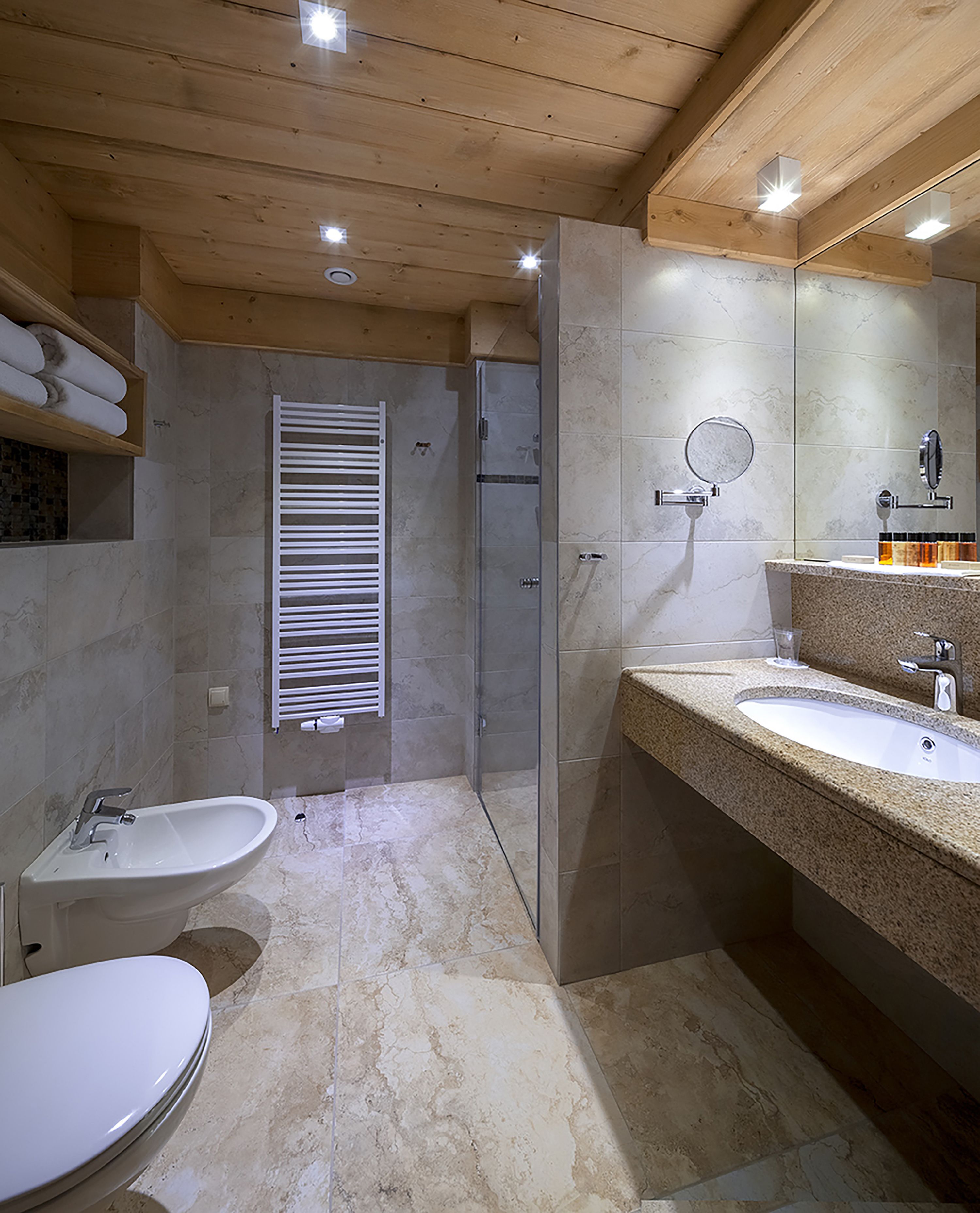 A modern bathroom with a shower, toilet, and sink.