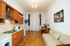 Una cocina compacta con armarios de madera, un microondas y una lavadora.