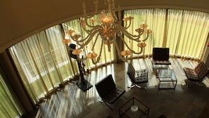A spacious living room with a large chandelier, leather sofas, and a glass coffee table. - Palazzo Giordano Bruno (Nola)
