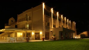 A multi-story hotel with outdoor seating and potted plants. - Palazzo Giordano Bruno (Nola)