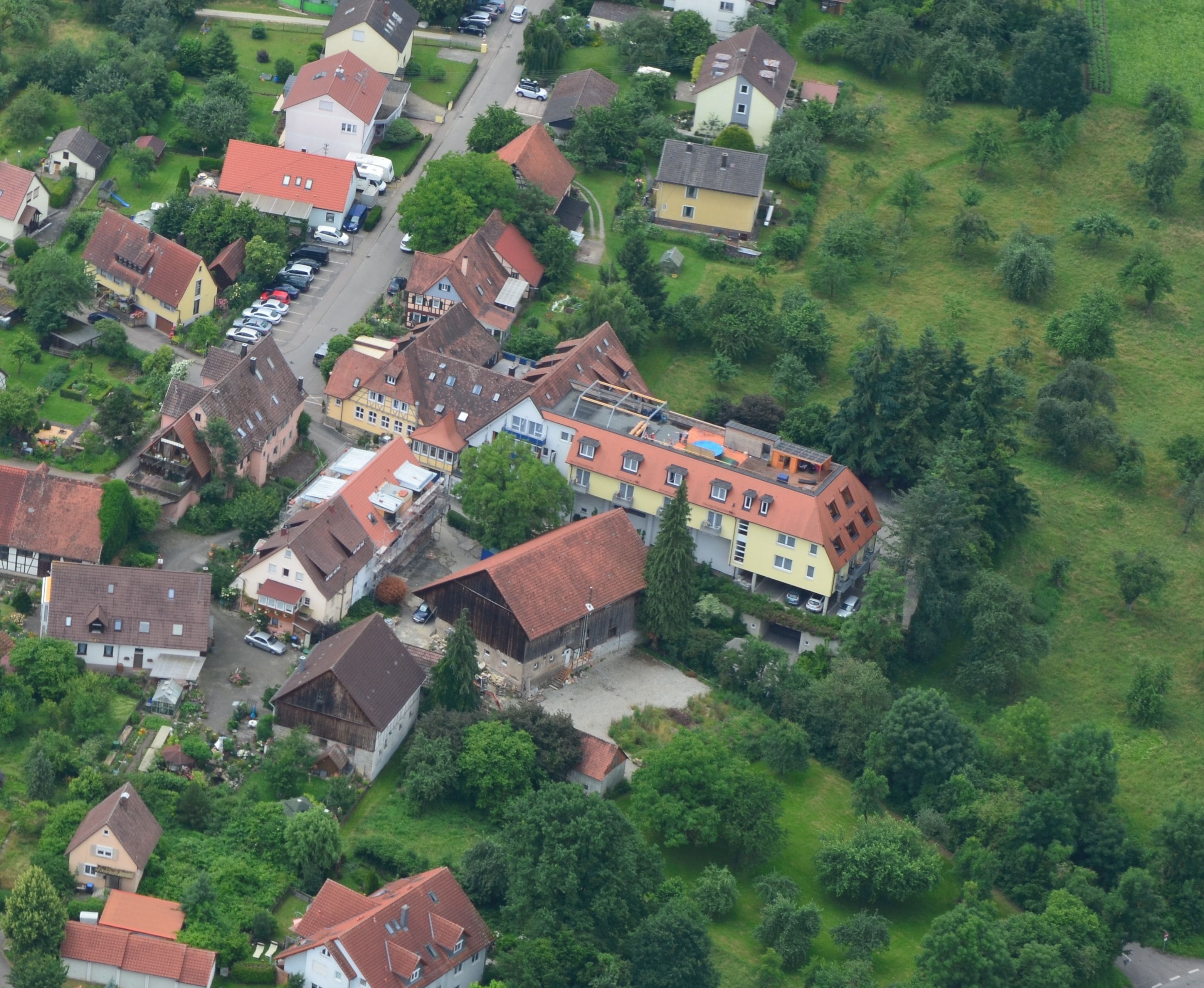 Vista aérea de una zona residencial con casas, calles y zonas verdes.