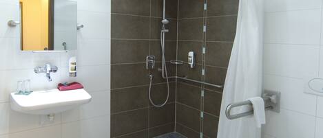 A modern bathroom with a shower, a sink, and a toilet.