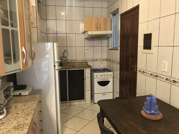 A compact kitchen with a refrigerator, stove, and sink. - Pousada Manga Rosa (Salvador)