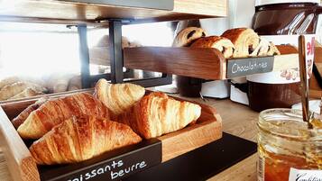 A bakery display with labeled sections for brioche sucrée, chocolatines, croissants beurre, and confiture.