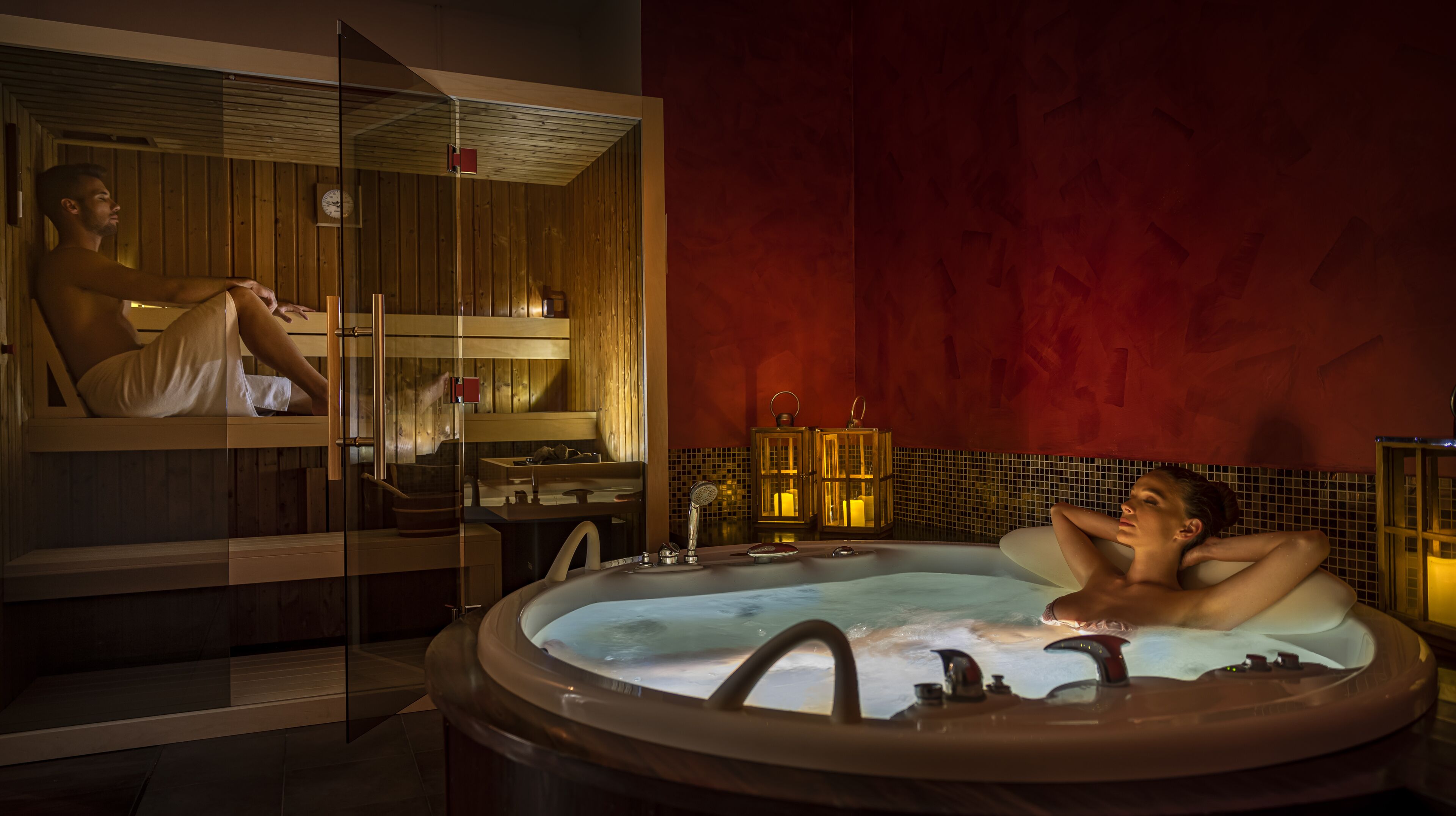 A spa room with a large bathtub, wooden paneling, and a red wall.