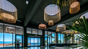A spacious lobby with large windows, a reflective marble floor, and modern circular light fixtures. - Grand Hotel Adriatic II (Opatija)