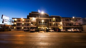 A multi-story hotel with a central entrance, multiple parking spaces, and a well-lit facade. - Hotel Mazatlan (Mazatlán)