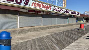 A boardwalk with closed shops, including 'Sandtropez' and 'Lucky Leo's'.