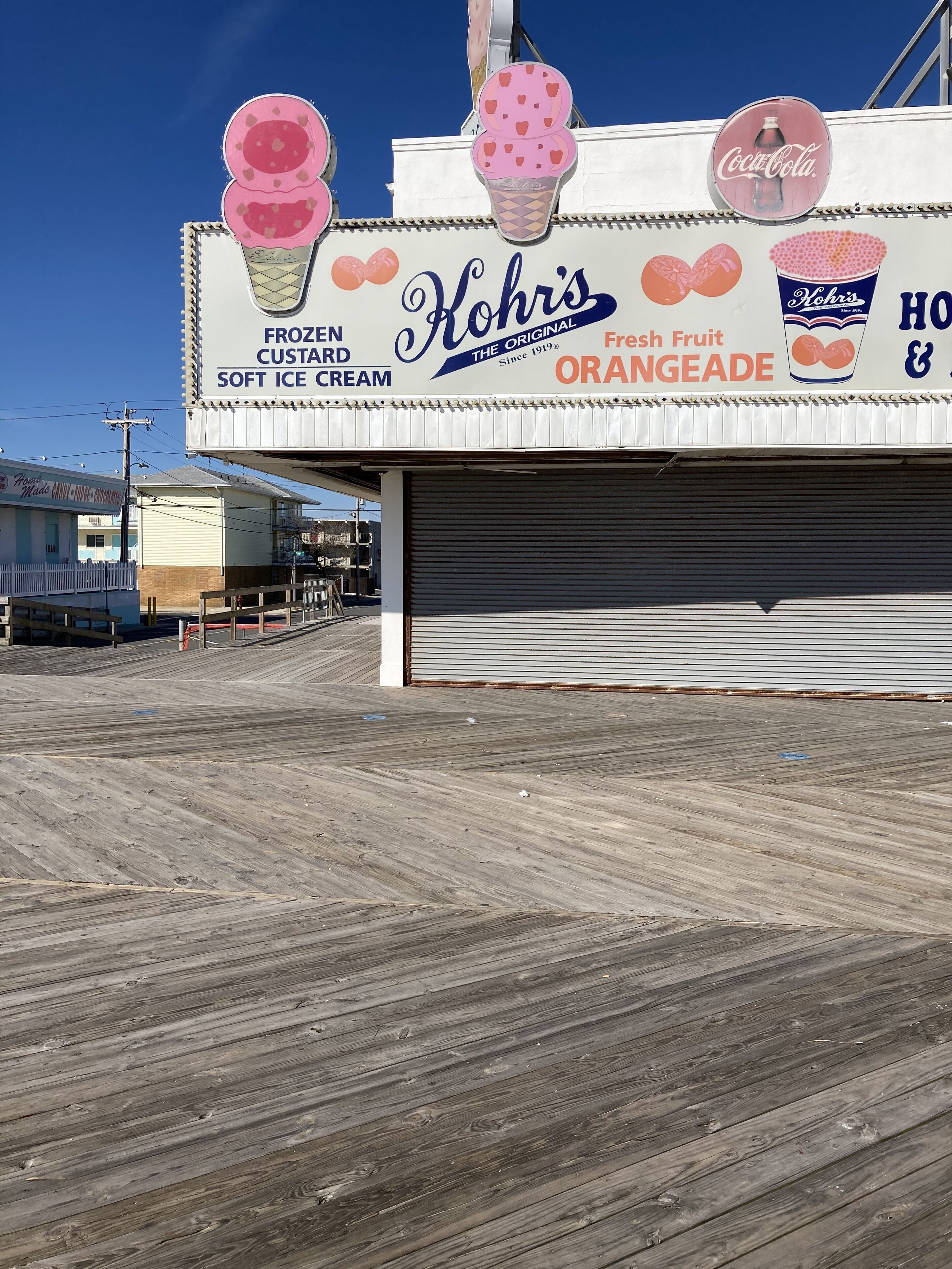A building with a large sign advertising frozen soft ice cream and orangeade.