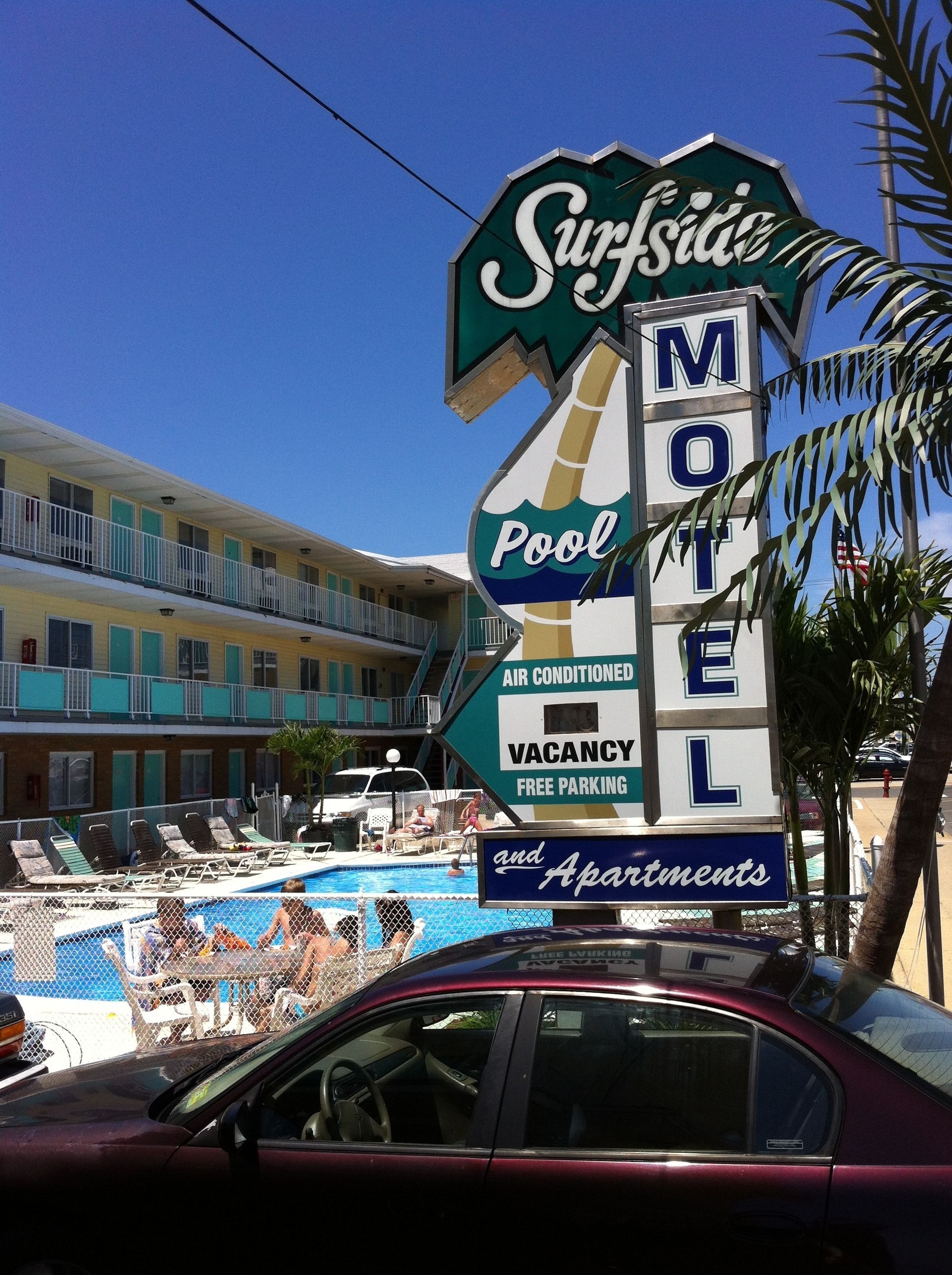Letrero de motel que indica piscina, aire acondicionado y estacionamiento gratuito.