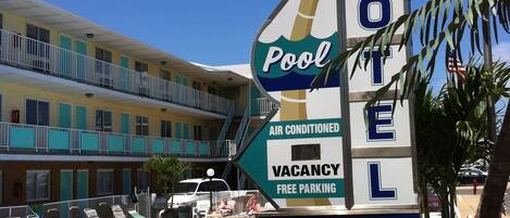 A motel sign with a pool, air conditioning, and free parking.