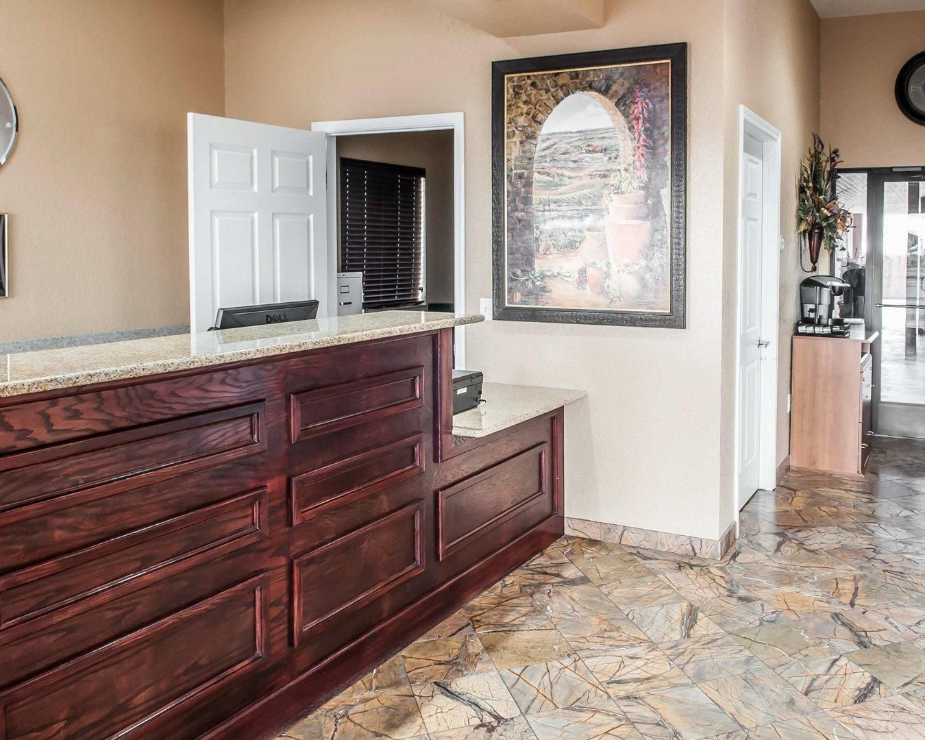 A bathroom with a wooden vanity, a shower area, and a large framed artwork on the wall.