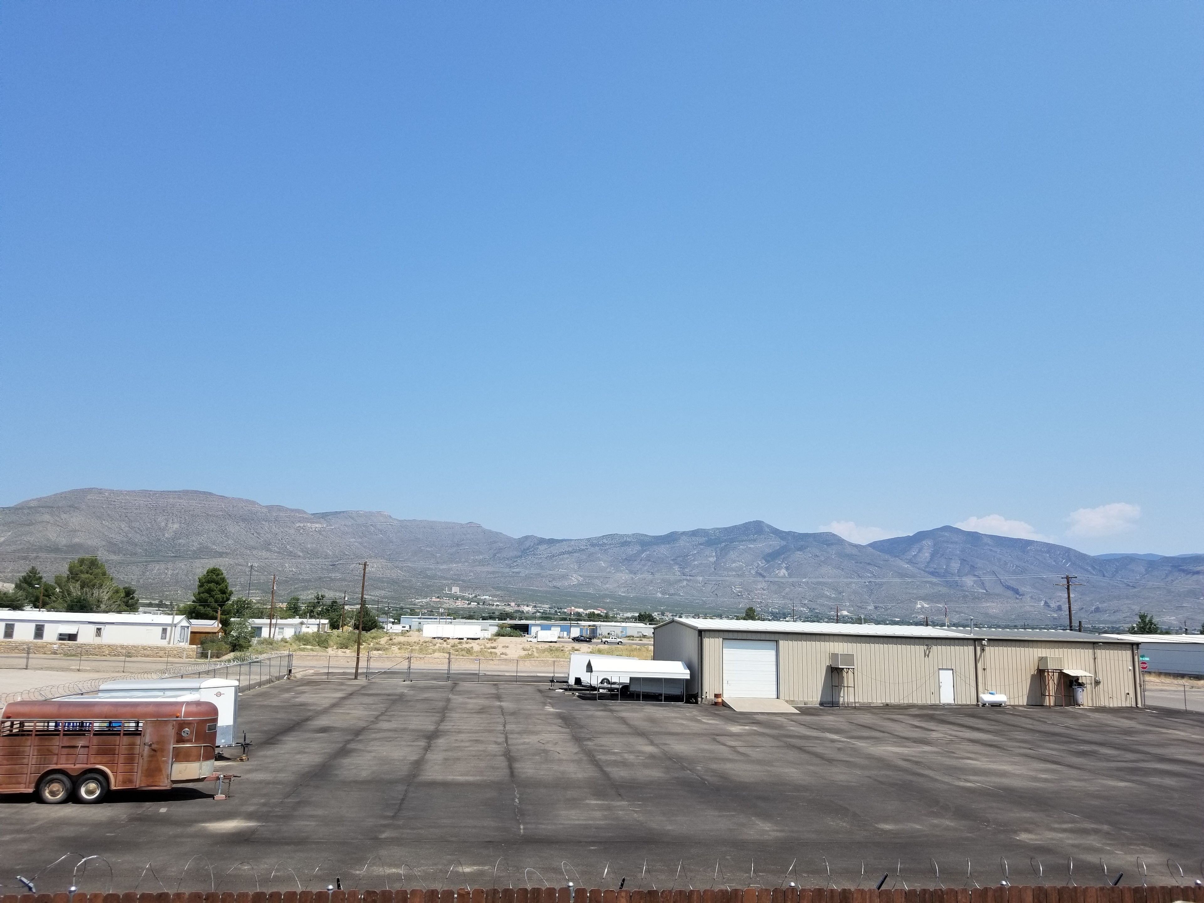 A large industrial area with a warehouse, a trailer, and a truck.