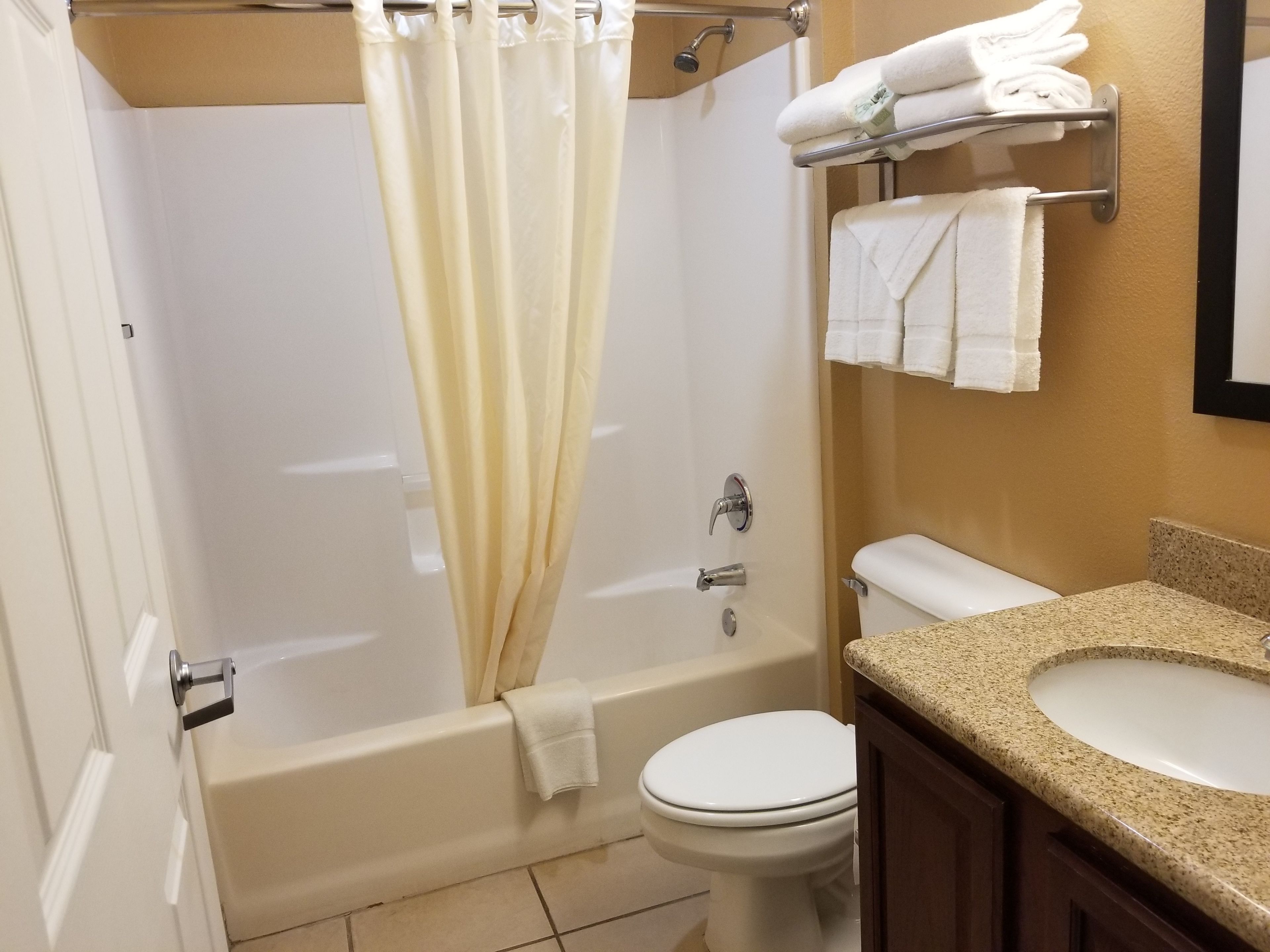 A bathroom with a bathtub, toilet, sink, and towel rack.