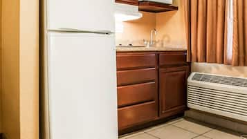 A kitchen with a white refrigerator, wooden cabinets, a microwave, and a built-in oven.