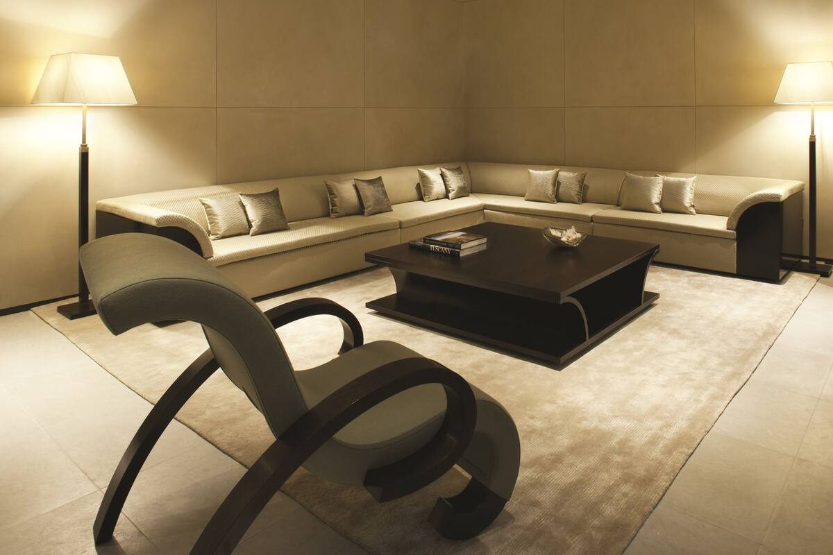 A modern living room with a sectional sofa, a coffee table, and two floor lamps.
