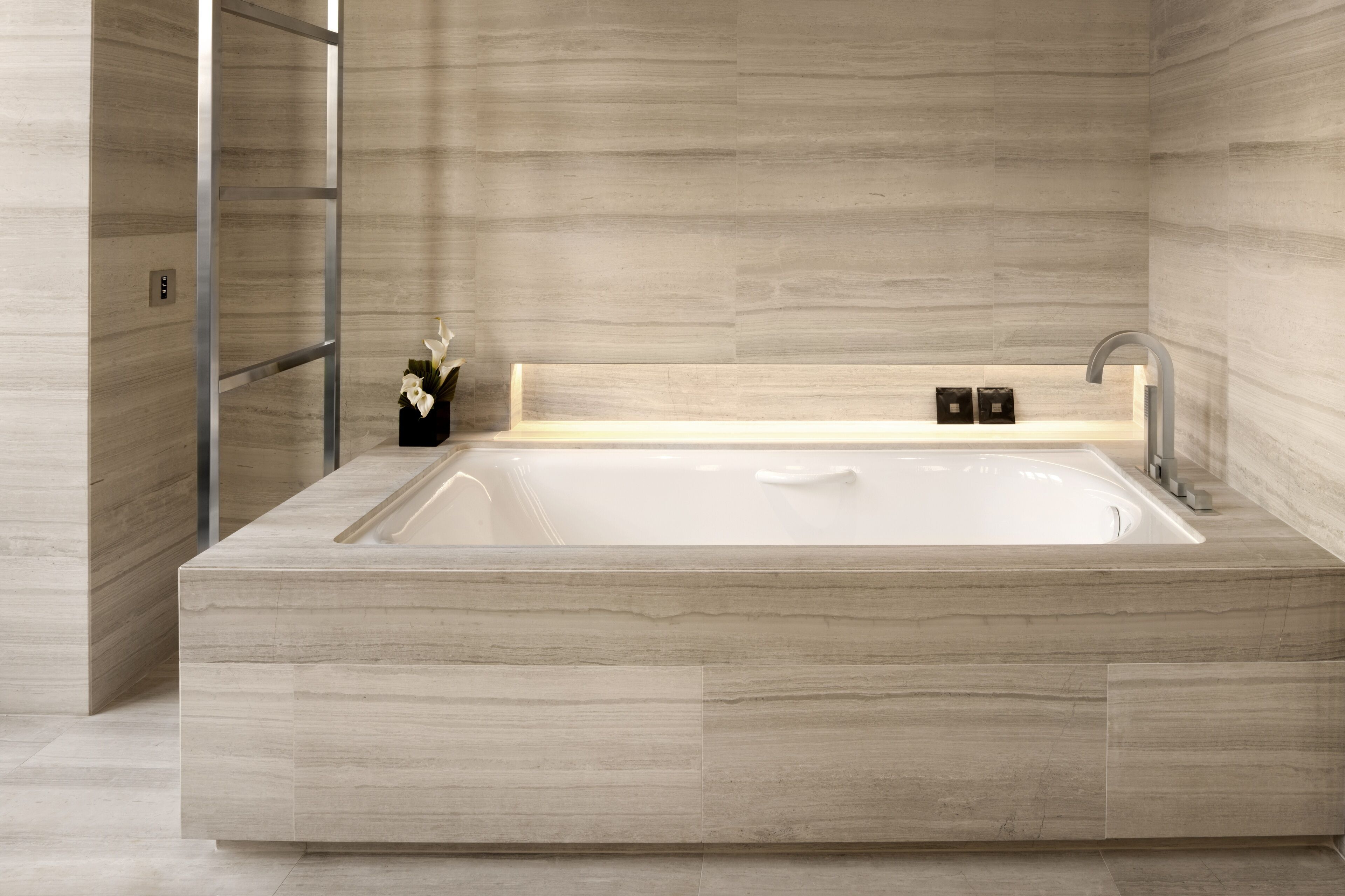 Un baño moderno con una bañera grande, cabina de ducha de vidrio y diseño minimalista.