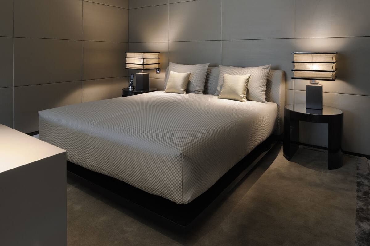 A modern bedroom with a large bed, two bedside tables, and a nightstand.
