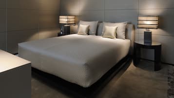 A modern bedroom with a large bed, two bedside tables, and a nightstand.