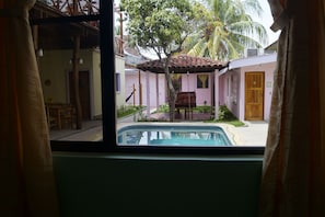 A view of a pool area with a wooden deck, a covered seating area, and a door marked with the number 12.