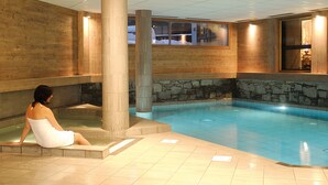 Ein Wellnessbereich mit Pool, Steinwänden und Holzvertäfelung.