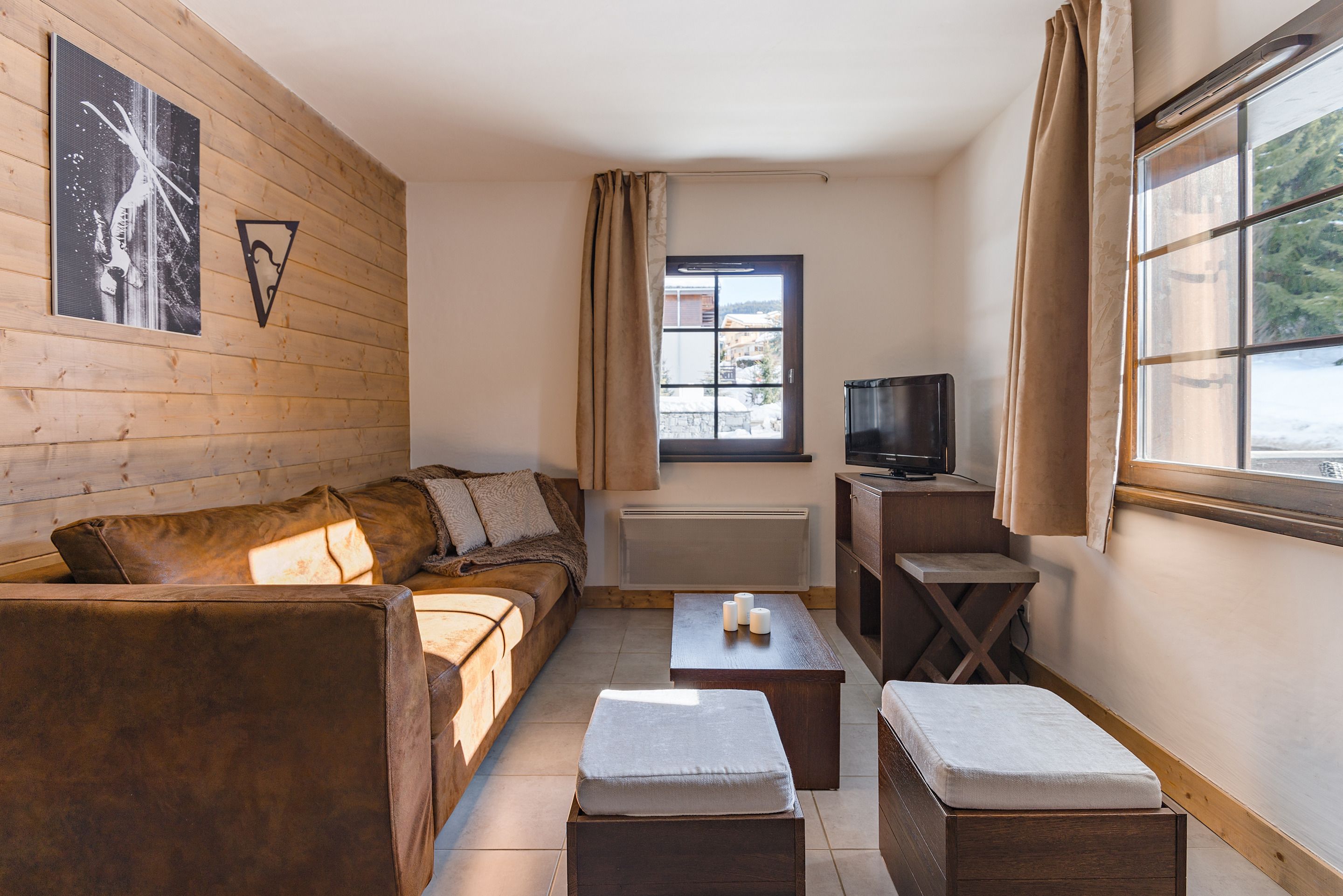 Una sala de estar acogedora con una pared de madera, un sofá, una mesa de centro y un televisor.