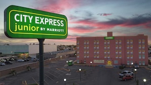 Un estacionamiento con un cartel que dice 'CITY EXPRESS junior by Marriott'.